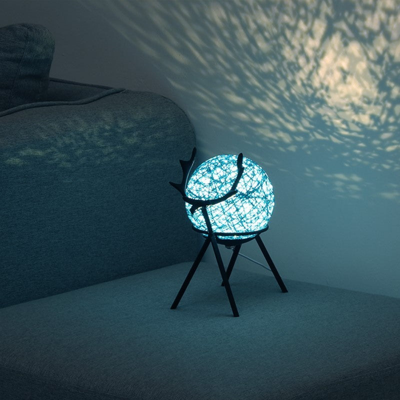 Bedroom girl retro style night light with glowing blue LED on black stand casting patterned light on wall
