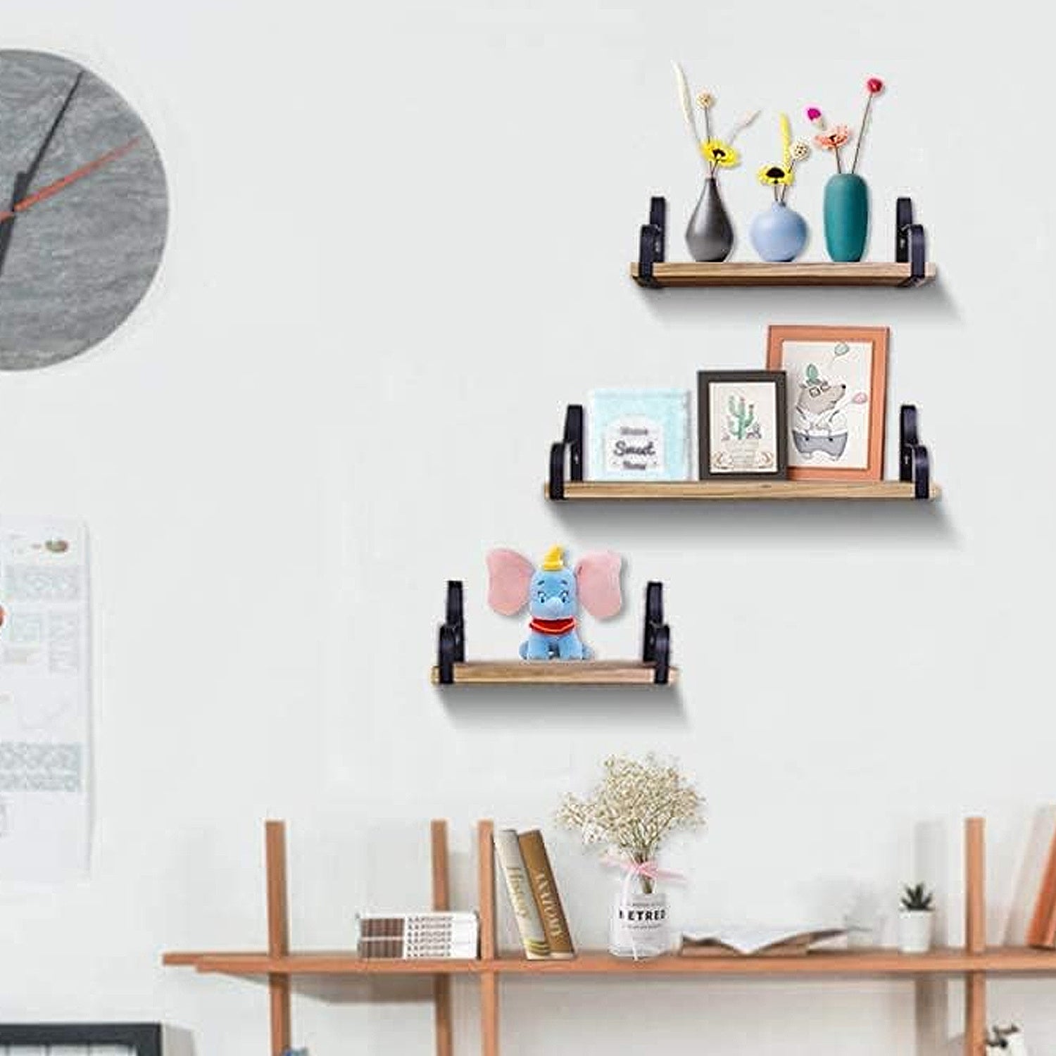 Modern wood floating shelves with black metal brackets displaying decor items on white wall.